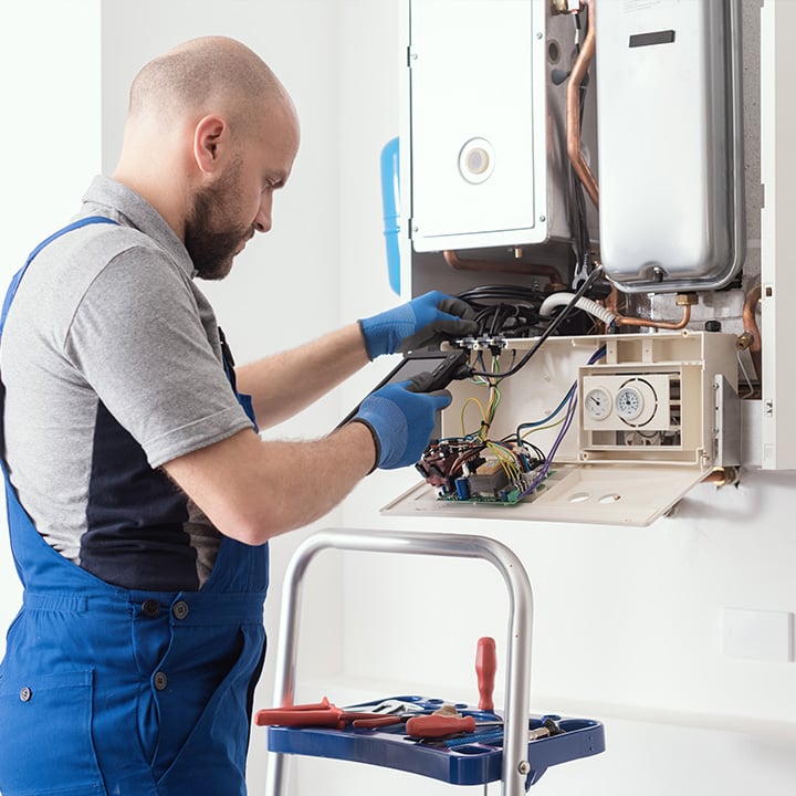 Picture of a man servicing a boiler